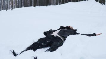 Happy young man in fairytale winter forest lying on snow. Media. Concept of religion and feeling unity with nature. video