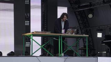 Georgia, Tbilisi - July 20, 2024. A DJ performs live on stage with electronic equipment and captivating visuals enhancing the energetic show. Clip video
