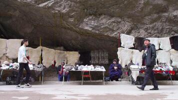 Georgia, Tbilisi - September 26, 2023. Bazaar with people in mountains. Stock footage. Tourist bazaar with souvenirs among rocky mountains. Souvenirs are sold high in mountains at foot of cliffs video