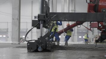 Workers are pouring concrete in a busy industrial setting, focusing on teamwork and tasks. Clip video