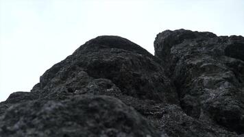 Giant rocks on cloudy sky background. Clip. Close up of grey stone texture. video