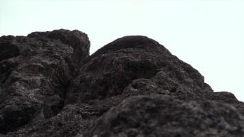 Giant rocks on cloudy sky background. Clip. Close up of grey stone texture. video