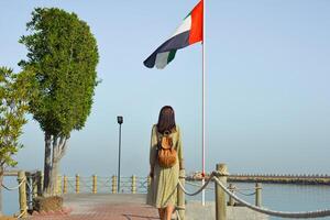 Girl on the beach posing against the backdrop of the UAE flag in Dubai. photo