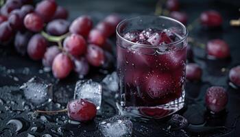 A Glass of Red Grape Juice with Ice Cubes and Grapes photo