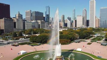Buckingham Fountain with Chicago skyline on sunny day. View of Buckingham Fountain in Grant Park with water jets creating a rainbow effect, set against the Chicago skyline on a clear day. video