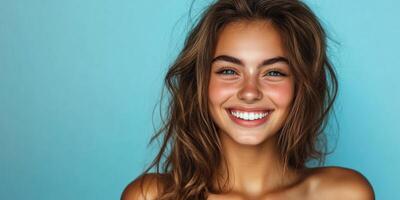 Portrait of a beautiful, cheerful, smiling young woman against a blue background with copyspace. photo