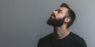 Bearded man standing against a gray background, copy space. photo