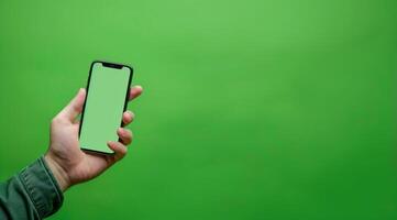 Advertising mockup with green color. A man holding cellphone with empty screen, lots of copy space photo