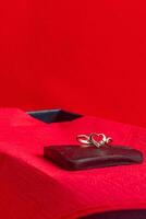 A ring with a small diamond on a chocolate heart on a red napkin photo