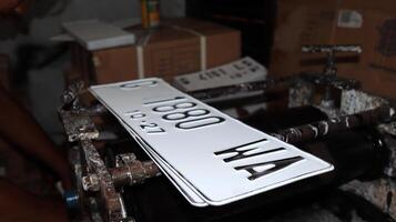 Workers making white license plates for a new type of motor vehicle, photo