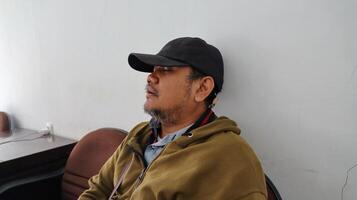 an adult man leeping exhaustedly leaning against the wall photo