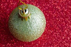 Top view of Golden Christmas ball on red background with customizable space for text or for wishes. Christmas celebration concept photo