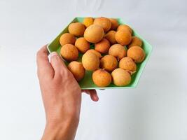 longan fruit on a green hexagon plate isolate on white background photo