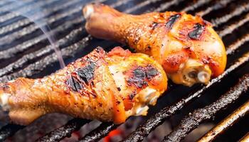 macro shot of grilled chicken legs with light smoke and hot coals photo
