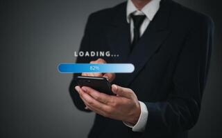 Businessman holding smartphone with loading button photo