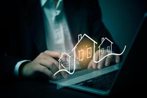 A man in a suit is using a laptop to show a house on the screen photo