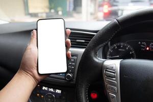 Man holding smartphone in the car with blank screen photo