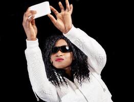 young african american girl in white sweater takes a selfie photo