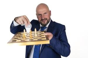 portrait of businessman in blue suit and tie with friendly expression showing light bulb on chessboard as symbol isolated on white background photo
