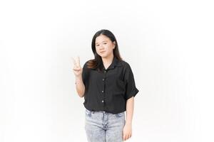 beautiful Asian woman poses with her hands to display the number 2, set against a white background photo