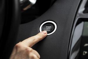 Women activates button to start and stop for car engine, pressing start engine button on a modern sports car photo