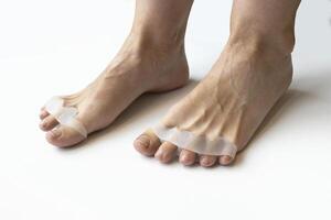 Bunion, hallux valgus. Silicone finger toe separator on feet isolated on white background. preparing for foot pedicure at home with nail separators photo