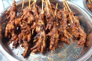 Grilled chicken skewers with spicy marinade on a metal tray. photo