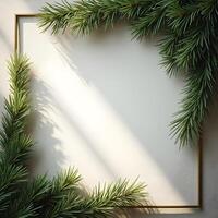 Christmas frame with fir branches and golden frame on white wall photo