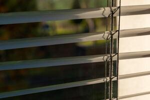 Sunlight filtering through closed blinds in a tranquil indoor space during the early morning hours photo