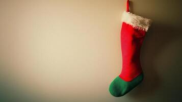 A red and green christmas stocking hanging on a wall photo