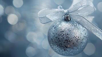 A silver christmas ornament with a bow on it photo