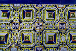 A collection of decorative ceramic tiles displays an array of intricate patterns and vibrant colors, including blues and greens photo