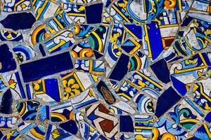 A collection broken of decorative ceramic tiles displays an array of intricate patterns and vibrant colors, including blues, reds, and greens photo