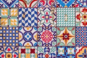 A collection ceramic of decorative ceramic tiles displays an array of intricate patterns and vibrant colors, including blues, reds, and greens photo
