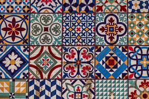 A collection spanish of decorative ceramic tiles displays an array of intricate patterns and vibrant colors, including blues, reds, and greens photo
