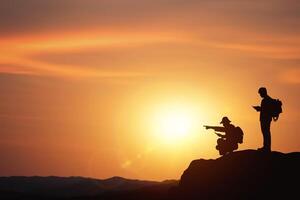 Planning and direction setting ideas. business concept with silhouettes of two businessmen planning trip on mountain with sunset background. photo