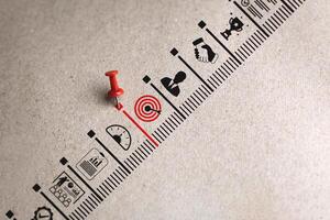 Red pin in scale target icon on paper background. Concepts and methods for developing organizations towards success. Business icons on paper represent establishing Strategy and Implementing plan. photo