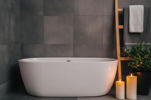Elegant bathroom with a modern freestanding tub, candles, and plants for relaxation. photo