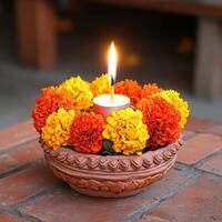 A beautiful clay diya surrounded by vibrant marigold flowers and a glowing candle. photo