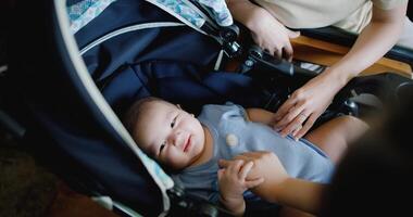 Selective focus, Two women are playing with a baby sleeping in a baby stroller. Family is enjoying a happy moment together. Happy lifestyle. photo