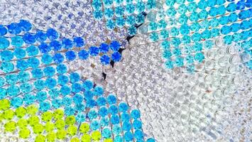 Decorative overhead ceiling curtain made from recycled plastic drinking bottles filled with colorful water and beautiful light reflections on surface, Concept of DIY home decor photo