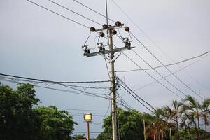 eléctrico utilidad polo con poder líneas y arboles en nublado día cielo foto