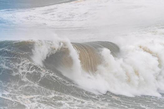 Close-up view of a powerful wave cresting with foam at Nazare in Portugal photo