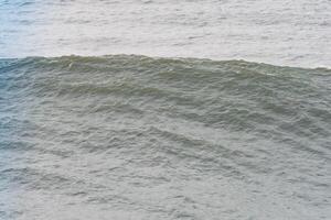 A massive ocean wave cresting with a textured surface in Nazare, Portugal photo