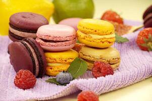 Stack of macaroons next to assortment of fruits photo