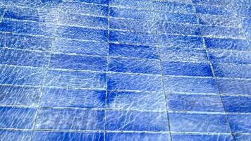 Rippling blue pool tiles create a refreshing summer vibe, perfect for promoting relaxation and leisure photo