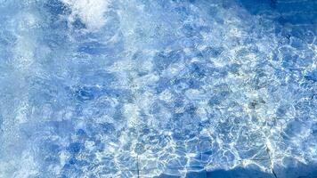 Crystal clear swimming pool water with shimmering reflections evokes summertime relaxation and leisure photo