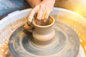 womens hands of a potter creating an earthen jar photo
