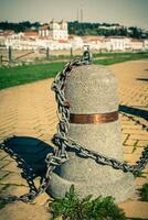 Stub posts linked in a chain on a quay photo