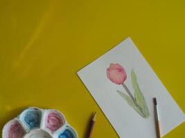 Drawing pastel minimalist pink tulips on paper with yellow background about art education photo